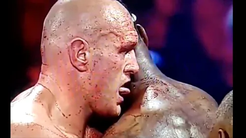 Moment bizar în meciul Tyson Fury – Deontay Wilder! Britanicul, surprins în timp ce lingea gâtul plin de sânge al americanului | VIDEO