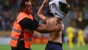 "Da, mamă, sunt...". O fană a intrat pe teren la meciul cu Grecia și a încercat să se dezbrace :). FOTO | Cum arată tânăra și ce mesaj purta
