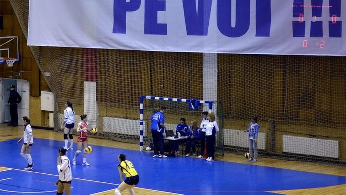 În România anului 2014, un banner indecent a fost afișat mai bine de 30 de minute la un meci de volei, sub privirile indiferente ale jandarmilor. UPDATE: Reacția primarului din Târgoviște: "E ca un tablou de Picasso"