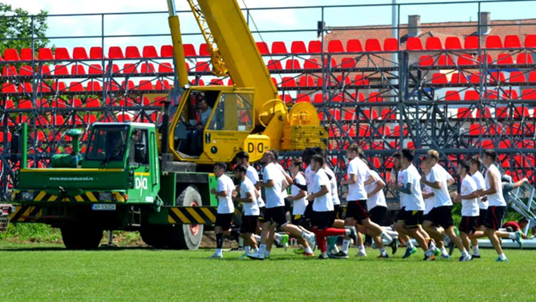 Au început lucrările pentru montarea gazonului sintetic la stadionul Motorul.** Utiștii se antrenează printre mașini, țevi și muncitori cu gândul că vor începe sezonul la Arad