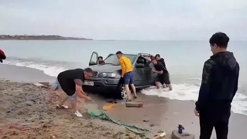 IMAGINEA ZILEI de 1 mai | BMW-ul a luat apă :). Un șofer a intrat cu mașina în mare, la Vama Veche, apoi a rămas blocat | VIDEO 