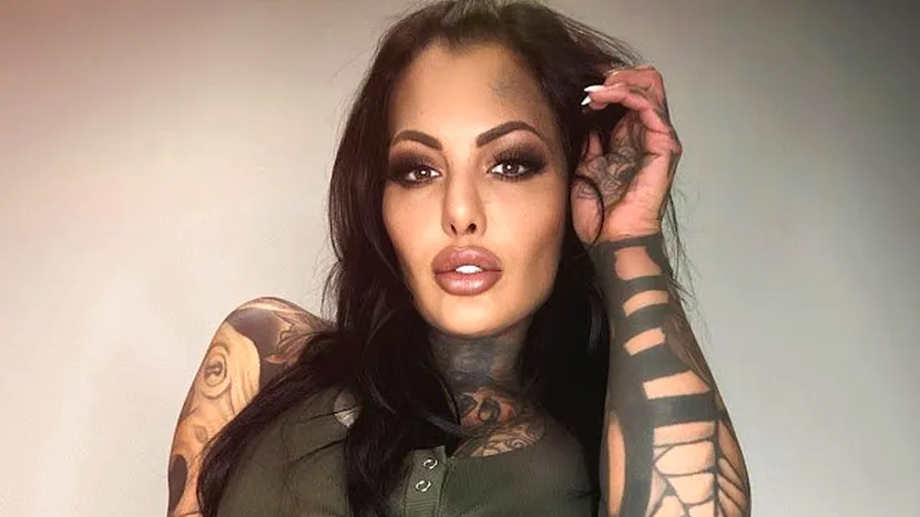 Un fotomodel cu aproape tot corpul acoperit de tatuaje îmbracă un set de lenjerie intimă